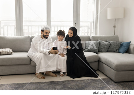 Cheerful Arabian mom, dad and son boy using mobile phone 117975338