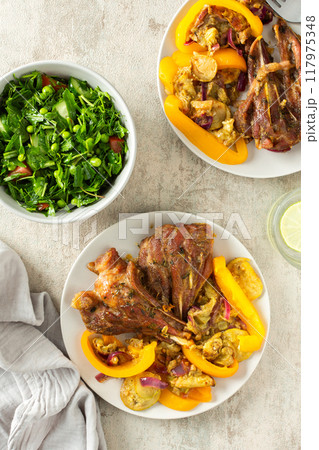 This delicious meal features tender baked turkey with zucchini, sweet peppers, and onions, paired with a vibrant salad of fresh seasonal vegetables and herbs for a balanced, nutritious option 117975348