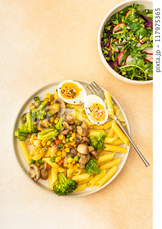 Pasta with fried mushrooms and broccoli, green peas and corn, fresh mix salad 117975365