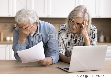 Stressed elderly couple reading awful news from bank 117975402