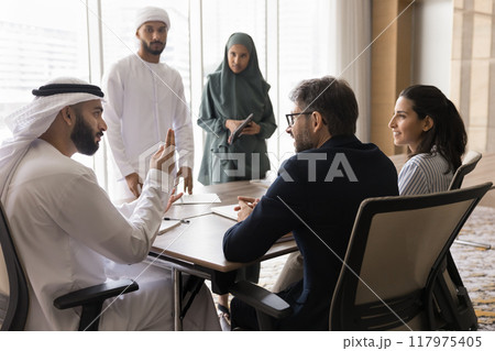 Diverse business team talking at meeting table Diverse business team talking at meeting table 117975405