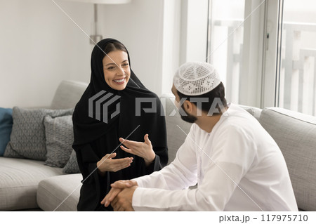 Cheerful Muslim couple talking and laughing at home 117975710