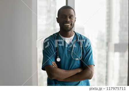 African man doctor in blue medical scrubs stand in office 117975711