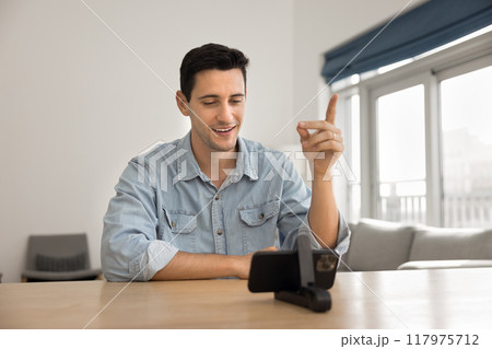 Positive Latin online coach man speaking at smartphone web camera 117975712