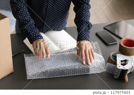 Small business owner packing package for dispatch to client Small business owner packing package for dispatch to client 117975801