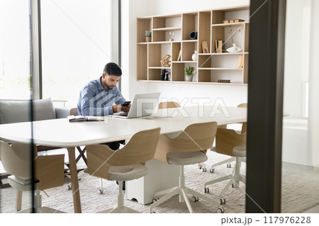 Focused young Arab employee man using digital device Focused young Arab employee man using digital device 117976228