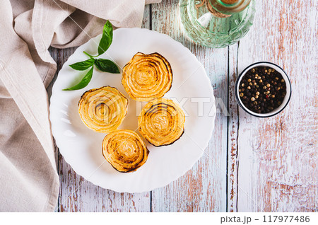Caramelized roasted onions and basil on a plate on the table top view Caramelized roasted onions and basil on a plate on the table top view 117977486