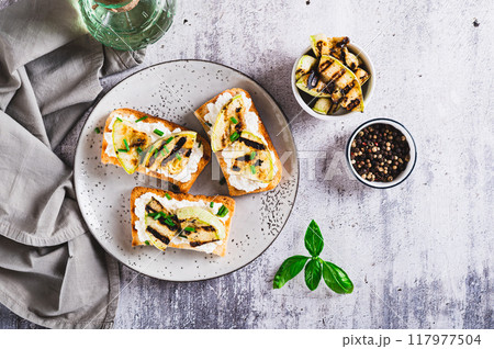 Sandwiches with ricotta, grilled zucchini and green onions on a plate top view 117977504