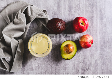 Refreshing avocado and apple smoothie in a glass on the table top view Refreshing avocado and apple smoothie in a glass on the table top view 117977524