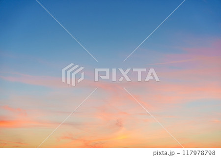 Breathtaking sunset sky showcasing vibrant pastel orange, pink, and blue colors over the horizon 117978798