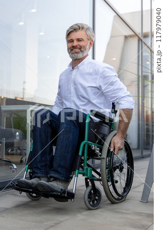 Mature man on a wheelchair looking determined and confident Mature man on a wheelchair looking determined and confident 117979040