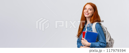 Teenagers, students and education concept. Cheerful lovely redhead female studying, going to univeristy or college, smiling carefree holding backpack and notebooks, standing white background 117979394