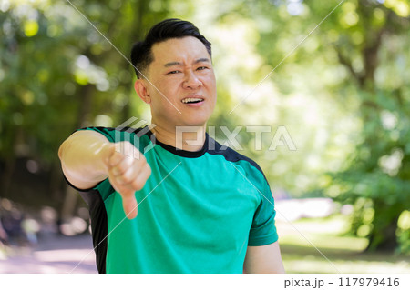Upset sportsman showing thumbs down dislike gesture expressing discontent disapproval dissatisfied 117979416