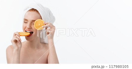 Great food for a healthy lifestyle. Beautiful young shirtless woman holding piece of orange standing against white background. 117980105