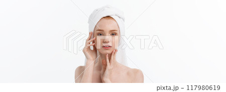beautiful model applying cosmetic cream treatment on her face on white. beautiful model applying cosmetic cream treatment on her face on white. 117980619