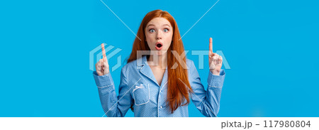 Wow look at this discounts. Amazed and surprised, excited young redhead woman in nightwear telling about stunning unexpected news, pointing fingers up, folding lips and stare astonished Wow look at this discounts. Amazed and surprised, excited young redhead woman in nightwear telling about stunning unexpected news, pointing fingers up, folding lips and stare astonished 117980804