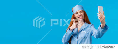 Sassy and popular redhead female blogger making live stream from bedroom talking about beauty and skincare routine, taking selfie on smartphone, show tongue and finger pistol Sassy and popular redhead female blogger making live stream from bedroom talking about beauty and skincare routine, taking selfie on smartphone, show tongue and finger pistol 117980907