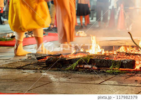 三重県津市　津観音で行われる十日観音の火渡りをする人と案内をするお坊さん 117982379