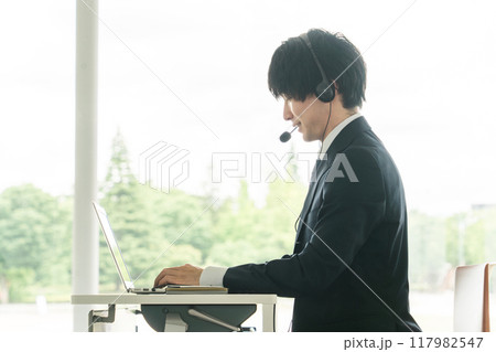 ヘッドセットをつけてオンライン会議をする若いビジネスマン ヘッドセットをつけてオンライン会議をする若いビジネスマン 117982547