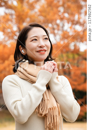 音楽を聴きながら紅葉狩りを楽しむ若い女性 音楽を聴きながら紅葉狩りを楽しむ若い女性 117982562