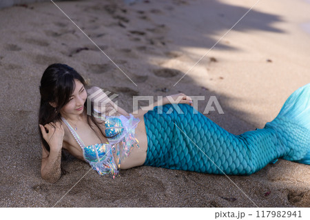 砂浜の日陰に寝そべる若い女性の人魚 117982941