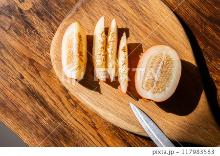 Freshly sliced vietnamese melon fruit on wooden cutting board. Freshly sliced vietnamese melon fruit on wooden cutting board. 117983583
