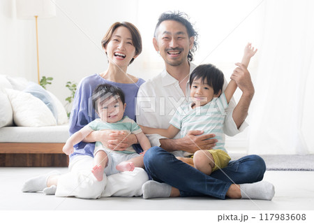 半逆光のリビングで笑顔のファミリーフォト 赤ちゃんと兄(兄弟)夫婦の4人家族幸せなシーンの愛情のイメ 半逆光のリビングで笑顔のファミリーフォト 赤ちゃんと兄(兄弟)夫婦の4人家族幸せなシーンの愛情のイメ 117983608