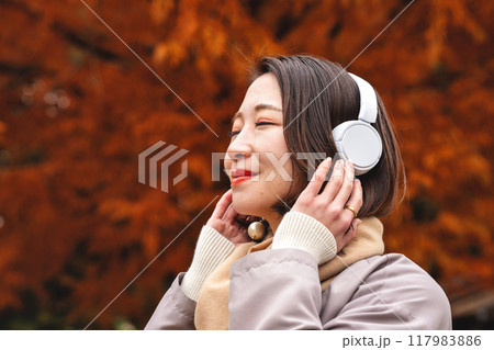 紅葉の中音楽に浸る若い女性 紅葉の中音楽に浸る若い女性 117983886