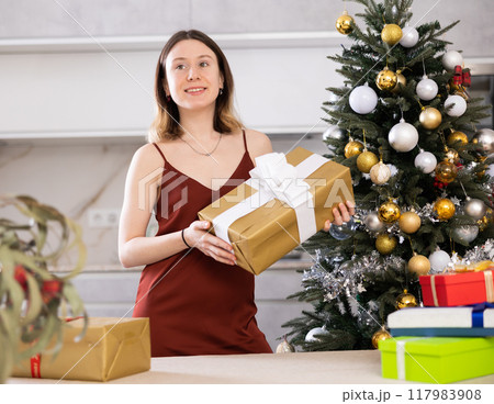 Cheerful woman poses against the background of a Christmas tree 117983908