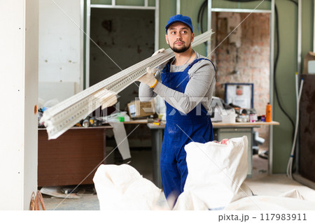 Worker carrying construction materials at renovating object Worker carrying construction materials at renovating object 117983911