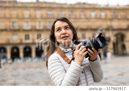 Woman photographer with camera capturing architecture of Plaza Mayor in Salamanca Woman photographer with camera capturing architecture of Plaza Mayor in Salamanca 117983917