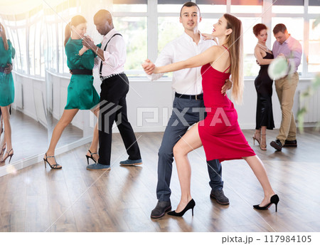 Couples dancing tango, enjoying dance moves in dance salon Couples dancing tango, enjoying dance moves in dance salon 117984105