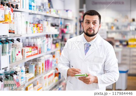 Portrait of male pharmacist working in drugstore 117984446