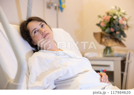 Calm woman resting in cozy hospital room after childbirth 117984620