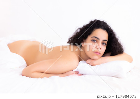 Young naked woman enjoying lying on bed Young naked woman enjoying lying on bed 117984675