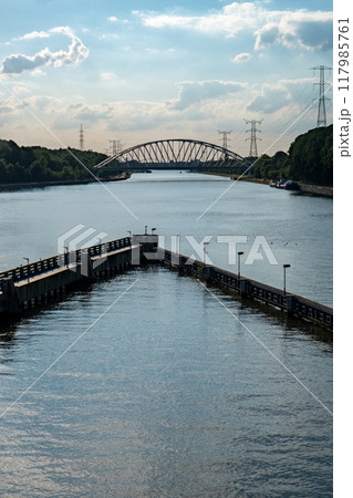 A beautiful scenic river view featuring a bridge and power lines, capturing the essence of nature A beautiful scenic river view featuring a bridge and power lines, capturing the essence of nature 117985761