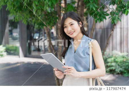 オフィス街でタブレット端末を持つビジネスウーマン 117987474