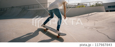 Skateboarder skateboarding at skatepark in city Skateboarder skateboarding at skatepark in city 117987843