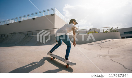 Skateboarder skateboarding at skatepark in city Skateboarder skateboarding at skatepark in city 117987844