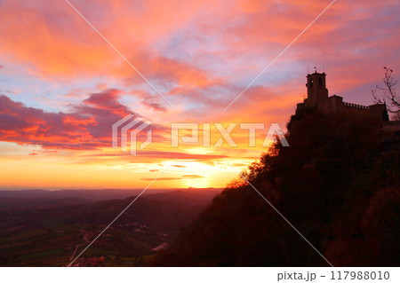 イタリアに囲まれたサンマリノ共和国 世界遺産ティターノ山のチェスタの塔シルエットと朝焼け空の景色 イタリアに囲まれたサンマリノ共和国 世界遺産ティターノ山のチェスタの塔シルエットと朝焼け空の景色 117988010