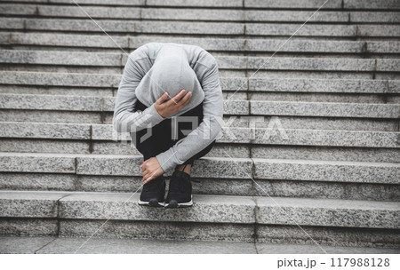 Upset woman sitting alone in city stairs 117988128