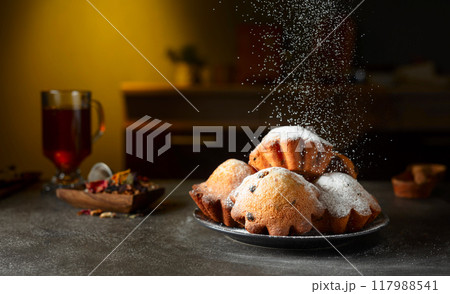 Homemade raisin cupcakes sprinkled with powdered sugar. 117988541