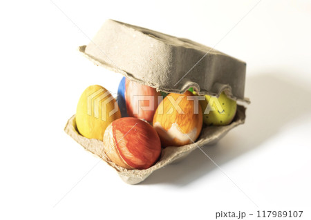 Easter eggs in a carton box on a white background. Easter eggs in a carton box on a white background. 117989107