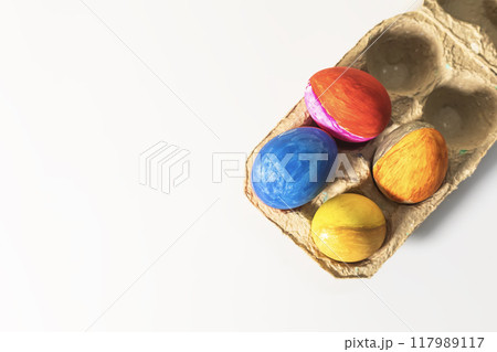Colorful easter eggs in a cardboard box on a white background. Colorful easter eggs in a cardboard box on a white background. 117989117
