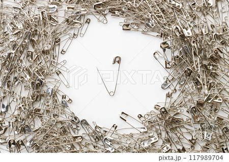 Open safety pins on white background. 117989704