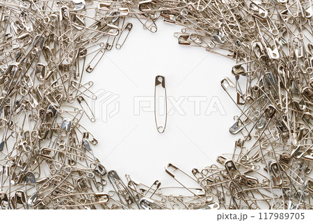 Safety pins on white background. 117989705
