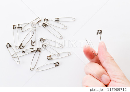 Safety pins on white background. 117989712