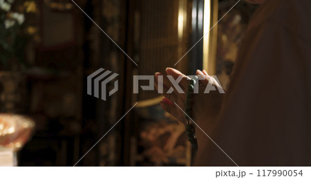 仏壇の前で手を合わせるシニア女性、高齢な女性 仏壇の前で手を合わせるシニア女性、高齢な女性 117990054