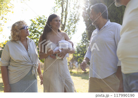 Happy multi generation family walking and talking in the park 117990190
