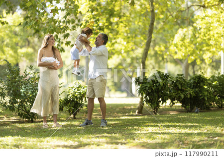Young family enjoying a sunny day at the park 117990211